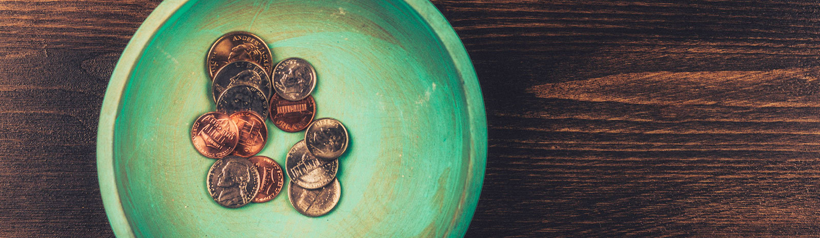 A handful of American coins in a green bowl