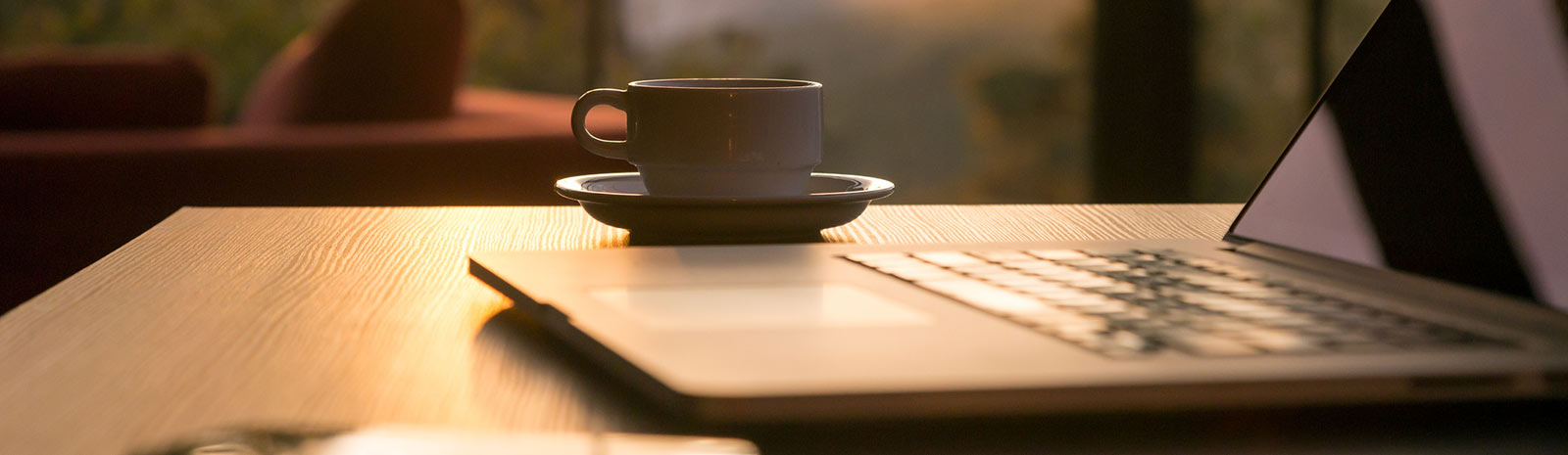 Coffee cup next to a laptop