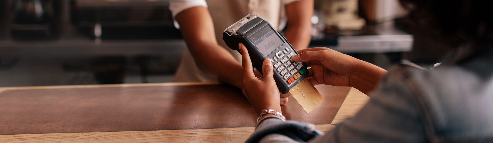 Close up of a person's hands using a credit card reader